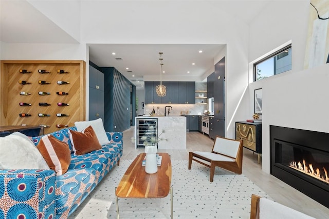 2010 Oxford Ave, Austin, TX 78704 - living room with wine cooler, light wood-type flooring, a glass covered fireplace, recessed lighting, and a towering ceiling