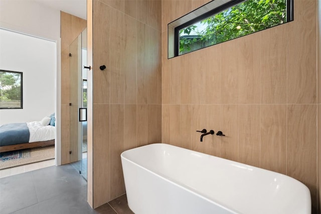 2010 Oxford Ave, Austin, TX 78704 - bathroom featuring a soaking tub, plenty of natural light, ensuite bathroom, and tile walls