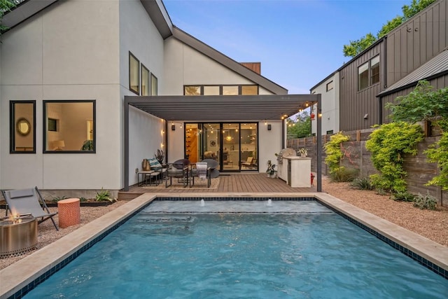 2010 Oxford Ave, Austin, TX 78704 - rear view of property featuring a wooden deck, an outdoor fire pit, and stucco siding