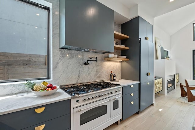 2010 Oxford Ave, Austin, TX 78704 - kitchen featuring range with two ovens, backsplash, extractor fan, open shelves, and gray cabinetry