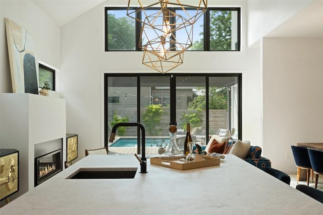 2010 Oxford Ave, Austin, TX 78704 - dining area with high vaulted ceiling, a chandelier, and a glass covered fireplace