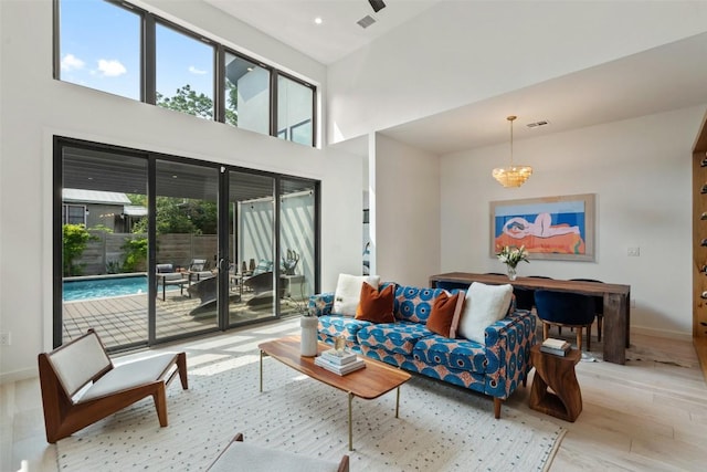 2010 Oxford Ave, Austin, TX 78704 - living area with a chandelier, baseboards, wood finished floors, and a high ceiling