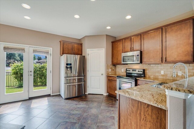 9837 Milla Cir Unit 72, Austin, TX 78748 - kitchen featuring stainless steel appliances, a sink, brown cabinetry, and recessed lighting