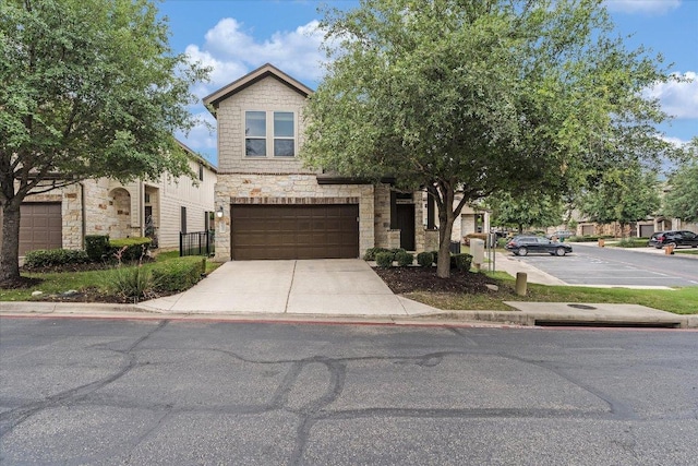 9837 Milla Cir Unit 72, Austin, TX 78748 - view of front of home featuring stone siding, an attached garage, and concrete driveway