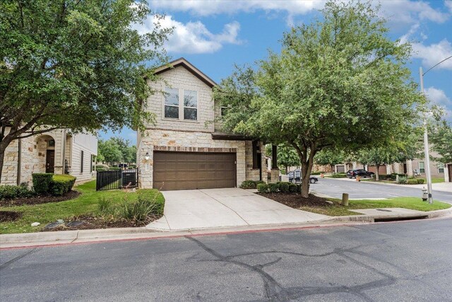 9837 Milla Cir Unit 72, Austin, TX 78748 - view of front of property featuring stone siding, an attached garage, concrete driveway, and a gate