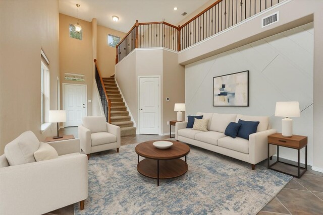 9837 Milla Cir Unit 72, Austin, TX 78748 - tiled living room featuring a high ceiling, stairs, and baseboards