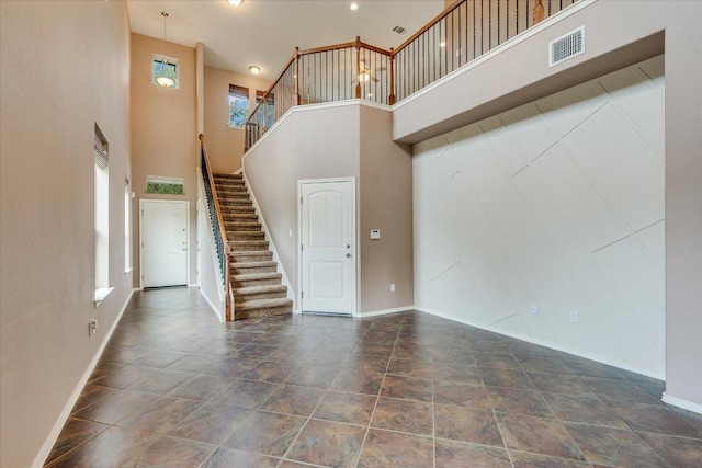 9837 Milla Cir Unit 72, Austin, TX 78748 - unfurnished living room featuring a towering ceiling, baseboards, and stairway