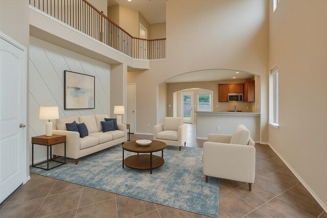 9837 Milla Cir Unit 72, Austin, TX 78748 - living area with a towering ceiling, dark tile patterned flooring, arched walkways, and baseboards