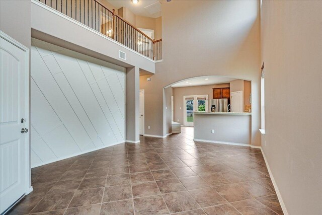 9837 Milla Cir Unit 72, Austin, TX 78748 - unfurnished living room with arched walkways, baseboards, and a high ceiling