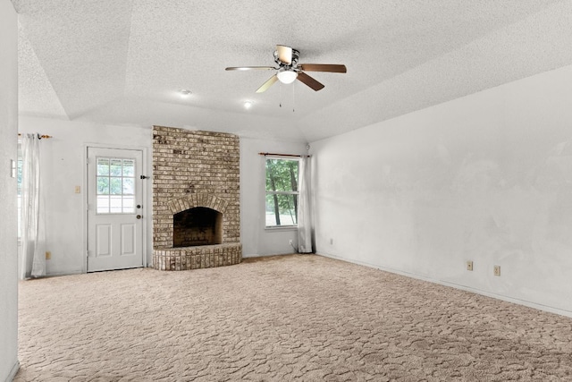 6509 Wagon Wheel Dr, Killeen, TX 76542 - unfurnished living room with a textured ceiling, carpet floors, a ceiling fan, a brick fireplace, and lofted ceiling