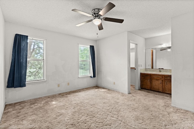 6509 Wagon Wheel Dr, Killeen, TX 76542 - unfurnished bedroom with light carpet, a textured ceiling, a sink, ensuite bathroom, and ceiling fan