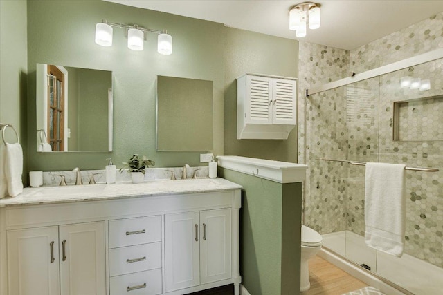 7006 Beckett Rd, Austin, TX 78749 - full bathroom with a shower stall, double vanity, toilet, and wood finished floors
