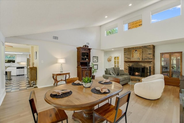7006 Beckett Rd, Austin, TX 78749 - dining space featuring light wood-style flooring, high vaulted ceiling, a fireplace, baseboards, and recessed lighting