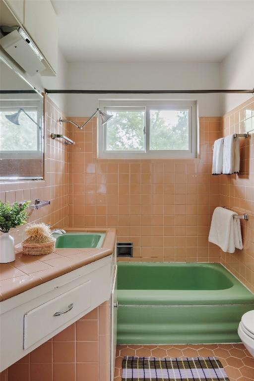 2300 Westworth Cir, Austin, TX 78704 - full bathroom with tile walls, shower / bath combination, vanity, tile patterned floors, and toilet