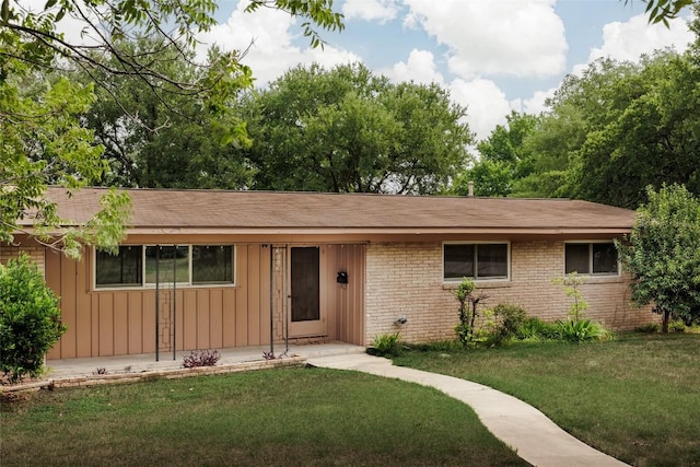 2300 Westworth Cir, Austin, TX 78704 - single story home with board and batten siding, brick siding, a front yard, and roof with shingles