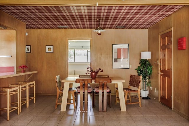 2300 Westworth Cir, Austin, TX 78704 - dining area with tile patterned flooring and wood walls