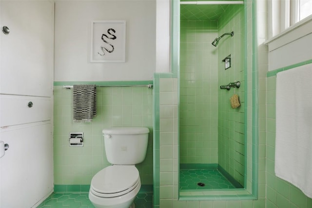 2300 Westworth Cir, Austin, TX 78704 - full bathroom featuring a shower stall, tile walls, a wainscoted wall, and tile patterned floors