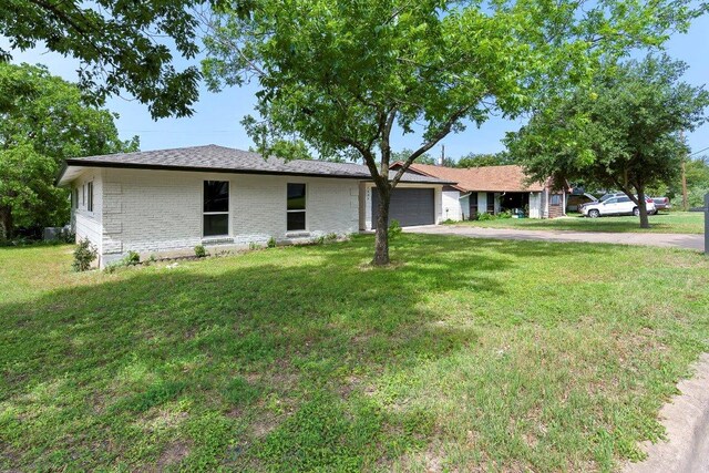 7302 Hartnell Dr, Austin, TX 78723 - ranch-style house featuring driveway, an attached garage, a front lawn, and brick siding