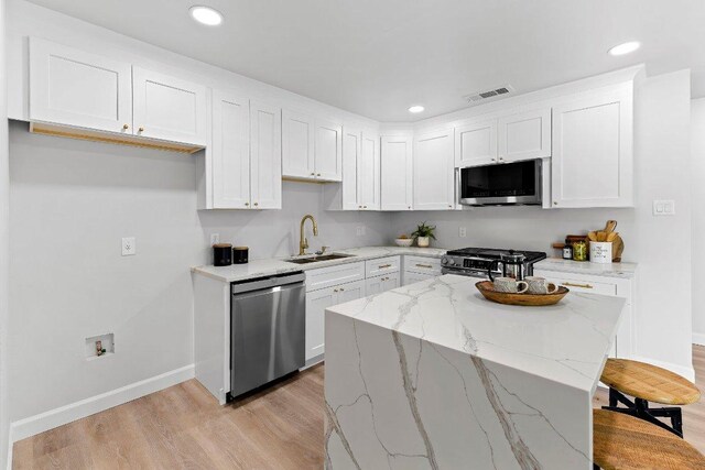 7302 Hartnell Dr, Austin, TX 78723 - kitchen with stainless steel appliances, a sink, baseboards, light wood-style floors, and recessed lighting