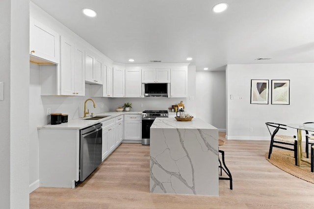 7302 Hartnell Dr, Austin, TX 78723 - kitchen featuring stainless steel appliances, a sink, a center island, baseboards, and white cabinets