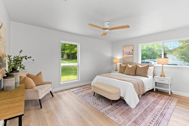 7302 Hartnell Dr, Austin, TX 78723 - bedroom with multiple windows, wood finished floors, baseboards, and ceiling fan