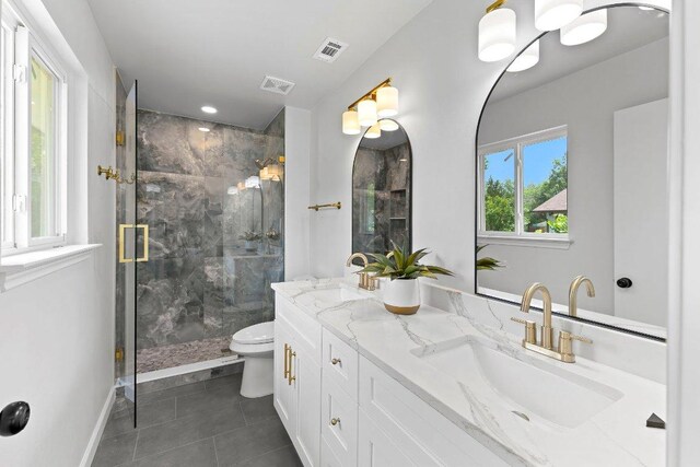 7302 Hartnell Dr, Austin, TX 78723 - bathroom with double vanity, tile patterned flooring, a marble finish shower, toilet, and baseboards