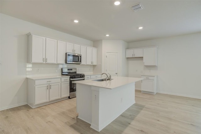 465 Brooks Ranch Dr, Kyle, TX 78640 - kitchen featuring appliances with stainless steel finishes, light wood-style floors, white cabinets, and recessed lighting