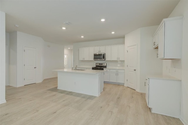 465 Brooks Ranch Dr, Kyle, TX 78640 - kitchen with stainless steel appliances, light wood-type flooring, light countertops, white cabinetry, and recessed lighting
