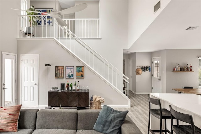 8504 Verona Trl, Austin, TX 78749 - living room featuring a towering ceiling, stairway, wood finished floors, and a bar
