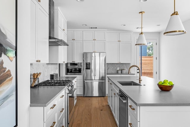 2105 Sl Davis Ave Unit 1, Austin, TX 78702 - kitchen with appliances with stainless steel finishes, wall chimney exhaust hood, a sink, a center island with sink, and decorative backsplash