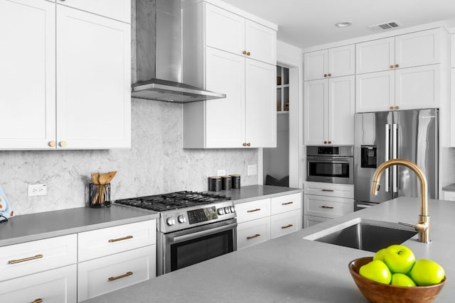 2105 Sl Davis Ave Unit 1, Austin, TX 78702 - kitchen with wall chimney exhaust hood, appliances with stainless steel finishes, a sink, white cabinetry, and tasteful backsplash