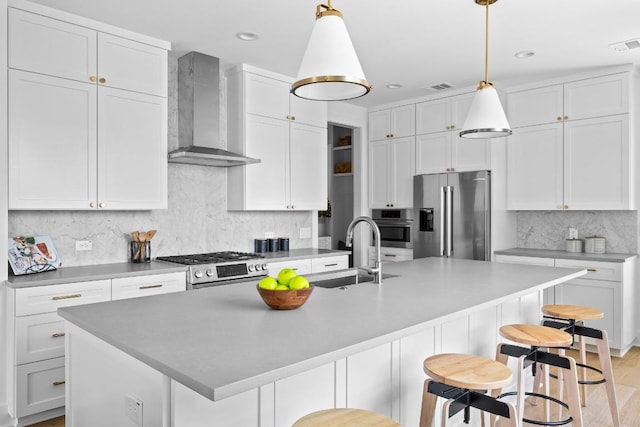 2105 Sl Davis Ave Unit 1, Austin, TX 78702 - kitchen with stainless steel appliances, wall chimney range hood, a kitchen breakfast bar, backsplash, and white cabinets