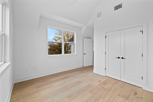 2105 Sl Davis Ave Unit 1, Austin, TX 78702 - unfurnished bedroom with light wood-style flooring, baseboards, high vaulted ceiling, and a closet