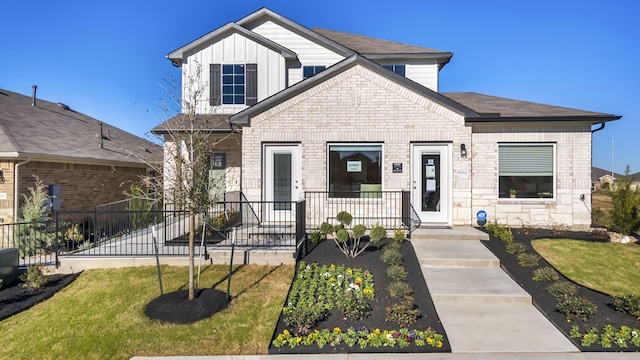 13702 Bothwell Pl, Manor, TX 78653 - view of front of house with board and batten siding, a front yard, and covered porch