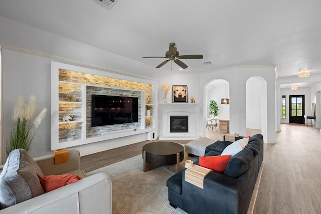 2565 Reunion Blvd, Austin, TX 78737 - living area featuring arched walkways, a glass covered fireplace, wood finished floors, and a ceiling fan