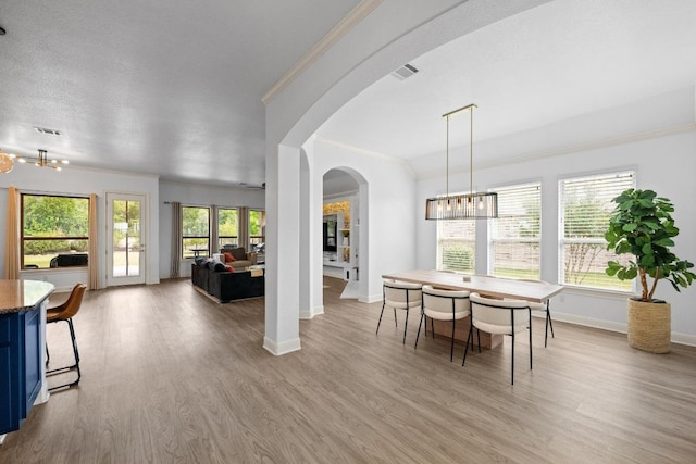 2565 Reunion Blvd, Austin, TX 78737 - dining area with baseboards, wood finished floors, a chandelier, crown molding, and arched walkways
