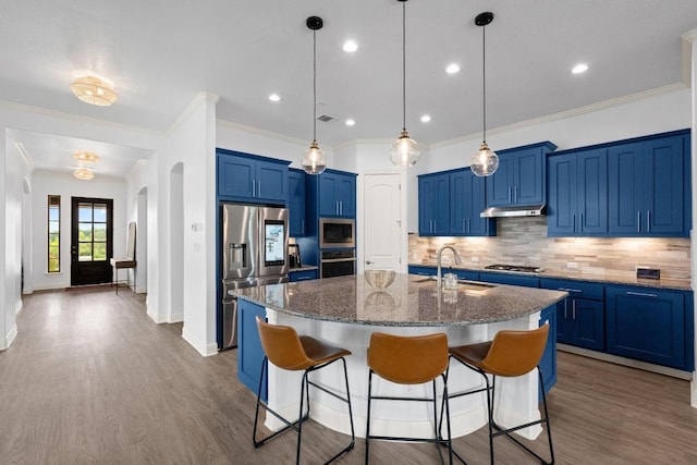 2565 Reunion Blvd, Austin, TX 78737 - kitchen featuring stainless steel appliances, a sink, blue cabinets, a kitchen breakfast bar, and decorative backsplash