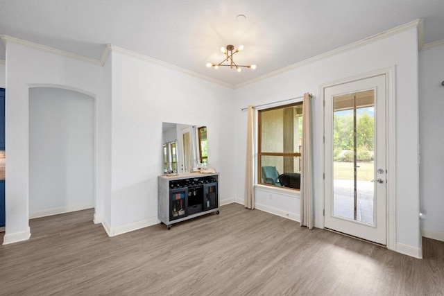 2565 Reunion Blvd, Austin, TX 78737 - unfurnished living room with light wood-style flooring, a chandelier, crown molding, baseboards, and arched walkways