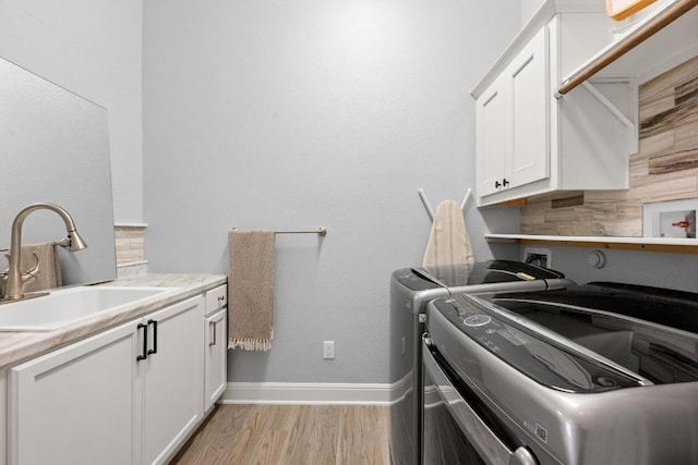 2565 Reunion Blvd, Austin, TX 78737 - washroom with washing machine and dryer, cabinet space, baseboards, and light wood finished floors