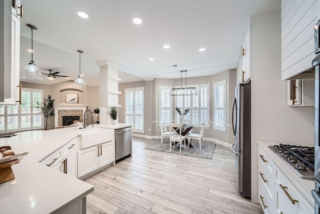 1237 Fall Creek Loop, Cedar Park, TX 78613 - kitchen featuring appliances with stainless steel finishes, a sink, a brick fireplace, light countertops, and recessed lighting