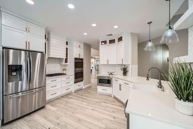 1237 Fall Creek Loop, Cedar Park, TX 78613 - kitchen featuring appliances with stainless steel finishes, a sink, a peninsula, decorative backsplash, and recessed lighting
