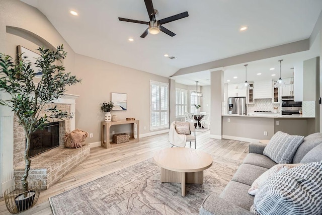 1237 Fall Creek Loop, Cedar Park, TX 78613 - living area with light wood-style floors, ceiling fan, a fireplace, vaulted ceiling, and baseboards