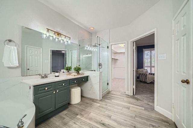 1237 Fall Creek Loop, Cedar Park, TX 78613 - bathroom with a shower stall, vanity, wood finished floors, and a spacious closet