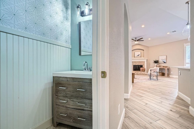 1237 Fall Creek Loop, Cedar Park, TX 78613 - bathroom with a brick fireplace, wood finished floors, vanity, baseboards, and a ceiling fan
