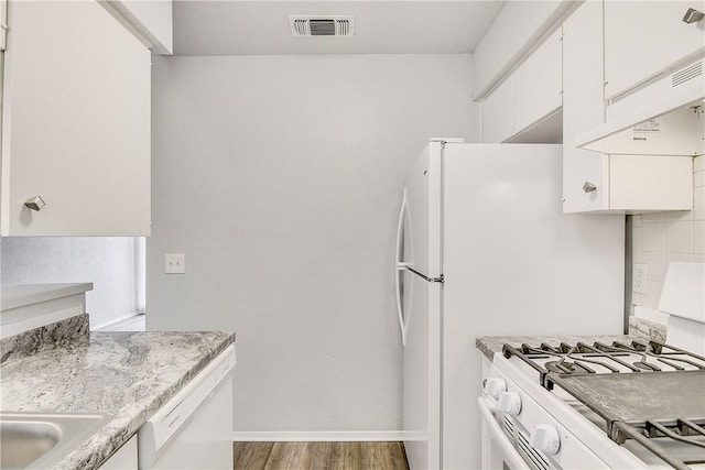 9406 Quail Meadow Dr, Austin, TX 78758 - kitchen with white appliances, under cabinet range hood, wood finished floors, white cabinetry, and baseboards