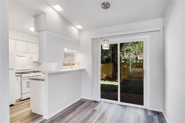 9406 Quail Meadow Dr, Austin, TX 78758 - kitchen with white appliances, under cabinet range hood, healthy amount of natural light, and white cabinetry