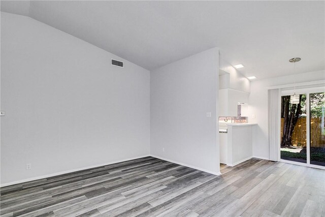 9406 Quail Meadow Dr, Austin, TX 78758 - unfurnished living room featuring wood finished floors, lofted ceiling, and baseboards