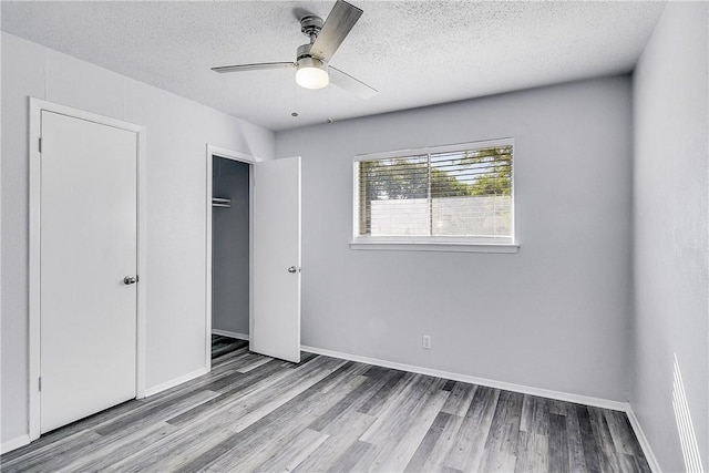 9406 Quail Meadow Dr, Austin, TX 78758 - unfurnished bedroom featuring wood finished floors, a textured ceiling, baseboards, and ceiling fan