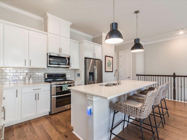 332 Adams St, Georgetown, TX 78628 - kitchen featuring stainless steel appliances, a sink, tasteful backsplash, white cabinets, and wood finished floors