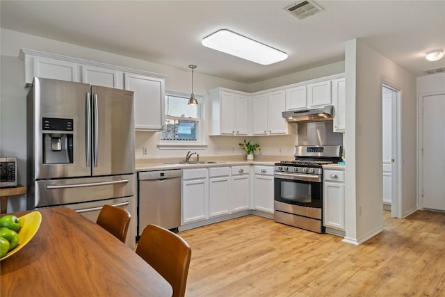 11710 Raymond C Ewry Ln, Austin, TX 78748 - kitchen with stainless steel appliances, under cabinet range hood, a sink, light countertops, and white cabinetry